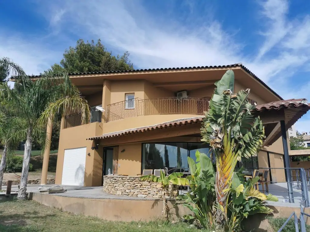 Villa contemporaine ravalée en enduit taloché ocre avec débord de toit sur charpente apparente — Castagne Couverture