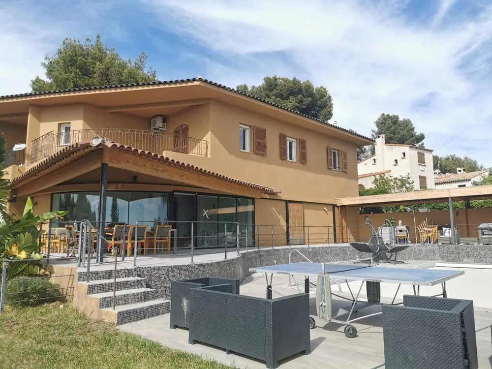 Villa en enduit ocre avec auvent sur charpente bois couvert en tuiles — Castagne Couverture
